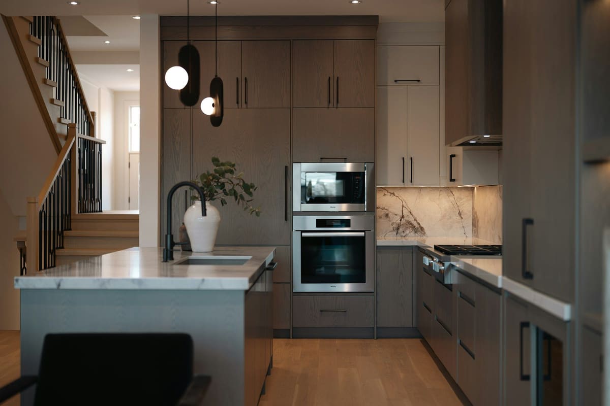 A modern fitted kitchen with built-in ovens and integrated appliances